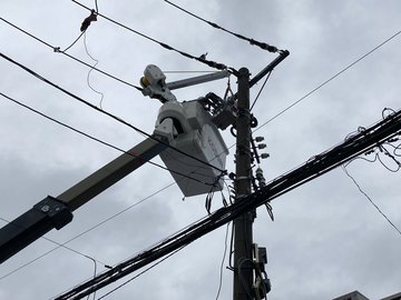 電柱上部で作業する高所作業車のバケット