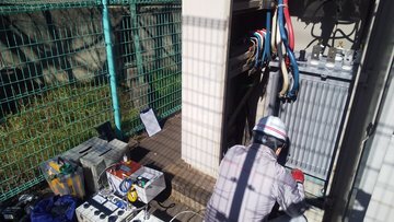 屋外キュービクル前でトランス交換作業を行う作業員