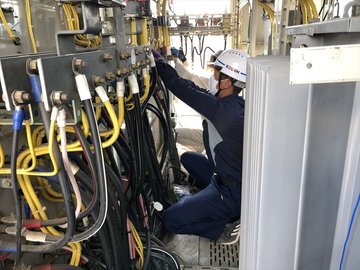キュービクル内で継電器用の配線を行う作業