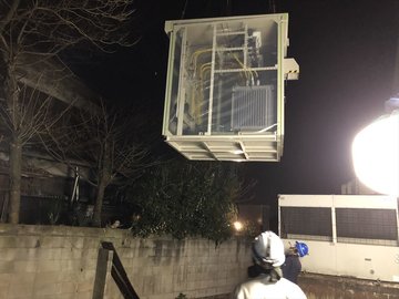夜間にクレーンで新しいキュービクルを設置する作業の様子