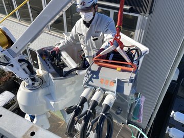 高所作業車で古いPASをクレーンで吊り上げ取り外す恒電社の電気工事士