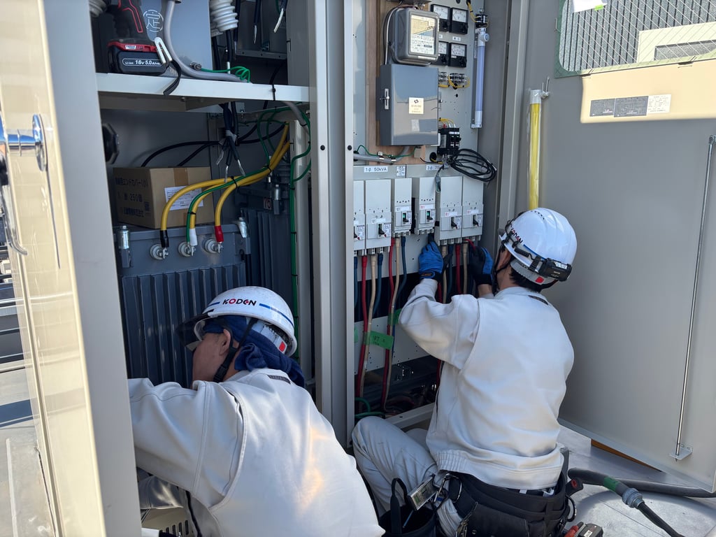 新設キュービクル内で配線接続作業を行う恒電社の作業員2名
