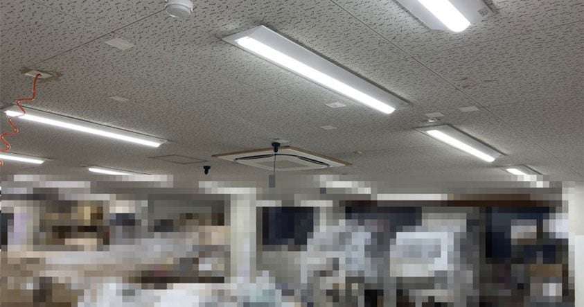 オフィスで向かい合い会話する男性2人、資料を手にする様子