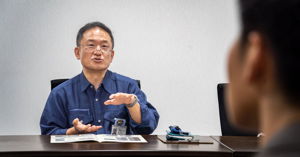 インタビューに応じる作業服姿の男性