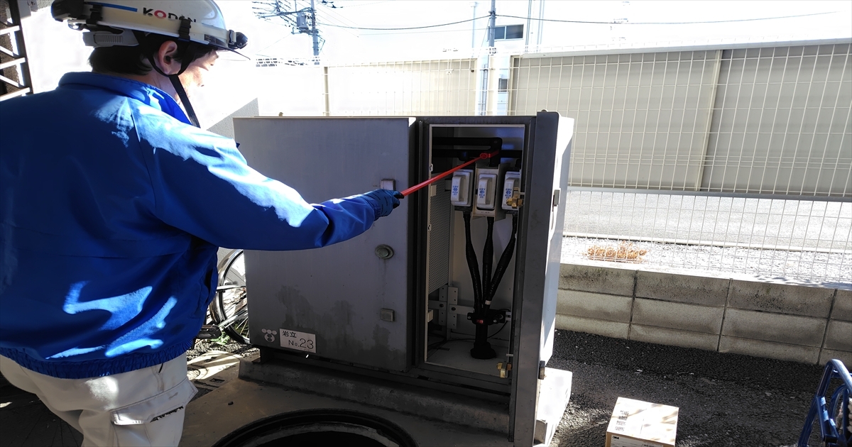 地上機器に検電棒で作業する恒電社の電気工事士
