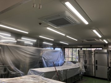 交換後の厨房（LED照明。厨房機器は養生シートで保護）