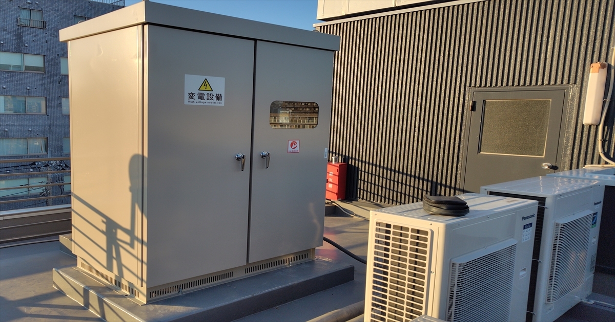 ビル屋上に設置された更新後のキュービクル（「変電設備」の表示板つき）
