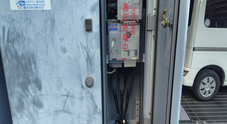 『高圧充電中』の表示がある高圧受電設備の扉内部