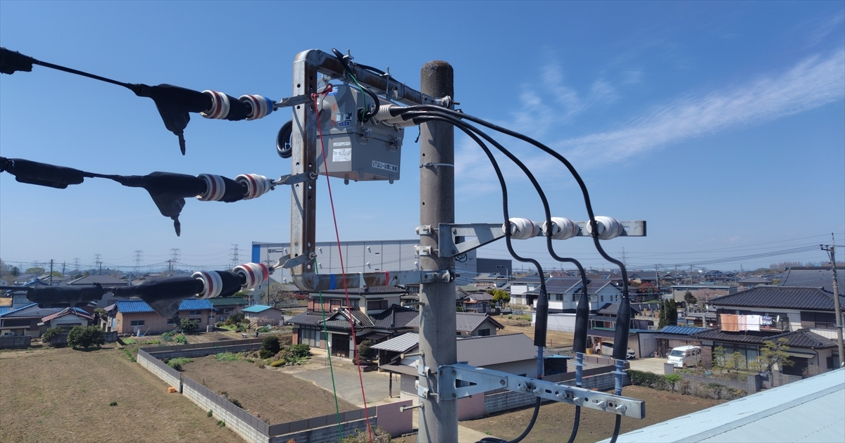電柱上部に取り付けられた交換後のPASと高圧ケーブル